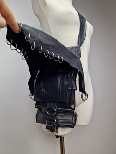 This lost-proof bag was created based on 10 year party experience! You can wear it in 3 different ways - as a two types of arm bag and fanny-pack. Łap holder makes it even more lost proof at the rave, festival or just during regular walk in the town. Base is made of upcycled materials - bike inner tubes! All elements were prepared to use it again:) on the top is upcycled leather cover which I made of old coat - i got it from my grandma and i Recycled it. Inside you will find 2 pocket and around metal holder for keys, wallet, water bladder, a dog leash and the likes. From the skin się is cotton to make it more comfortable for your body:) I add a lot of metal rounds because it looks like a piercing and bag has super cool, wild aura! Auuu!  If you want me to make custom order for you, based o Punk Leather Bag For Cosplay, Cyberpunk Steampunk, Steampunk Goth, Water Bladder, Upcycled Leather, Upcycled Materials, Rave Festival, Inner Tubes, Cool Necklaces