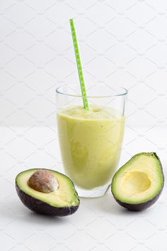 an avocado smoothie in a glass with a straw