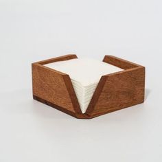 a napkin holder made out of wood and white paper