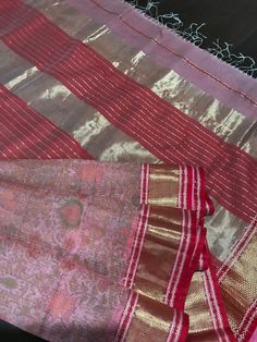 This is a very elegant maheswari silk cotton saree in peach shade. Saree is woven in kota checks style with elegant subtle prints all over the saree. Saree has double borders with gold zari and pallu has beatiful thick zari pattern. Saree comes with an unstitched blouse piece with double borders. This is a notch above the maheswari silk cotton saree because of the kota style weave. Saree is finished with tassels and falls and pico are done. Colour may vary slightly depending upon the lighting and individual device settings. Handloom products may have some irregularities. Dry clean only only. All sales are final. Pink Handloom Tissue Silk Saree, Pink Tissue Silk Handloom Saree, Pink Cotton Silk Dupatta With Zari Weaving, Pink Handloom Tussar Silk Dupatta, Pink Slub Silk Dupatta For Puja, Pink Handloom Cotton Silk Traditional Wear, Red Cotton Silk Dupatta With Weaving Work, Pink Raw Silk Saree With Weaving Work, Pink Weaving Work Dupatta For Festivals