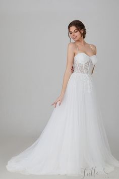 a woman in a white wedding dress posing for the camera with her hand on her hip