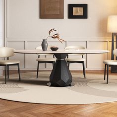 a dining room table with chairs and a vase on the top, in front of a white wall