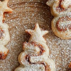 several pastries are arranged on a plate with powdered sugar and star shaped cookies