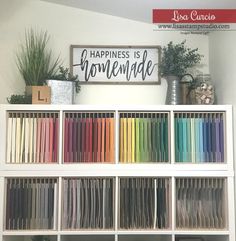 a book shelf filled with lots of books and papers on top of each other in front of a sign that says happiness is homemade