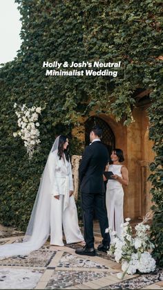 a bride and groom standing in front of an ivy covered wall at their wedding ceremony