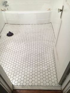 a bathroom with a toilet, bathtub and tiled floor in the shower stall area