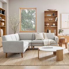 a living room filled with furniture and a large window in the center piece, surrounded by bookshelves