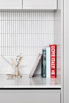 a book shelf with two books and a vase on it