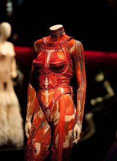 mannequins are displayed in an exhibit with red and white paint on them