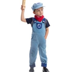 a young boy in overalls holding a baseball bat