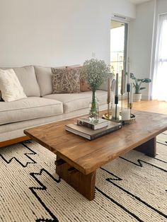 a living room with a couch, coffee table and rug on the floor in front of it