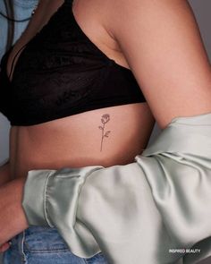 a woman's stomach with a flower tattoo on it