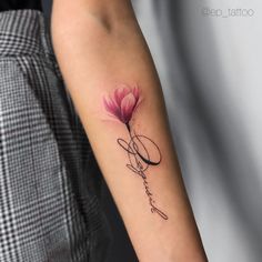 a woman's arm with a pink flower and the word love tattooed on it