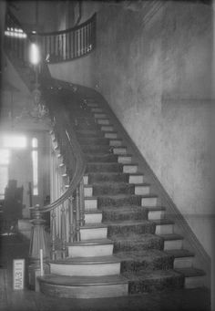 an old black and white photo of a staircase in a building with stairs leading up to the second floor