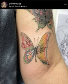 a colorful butterfly tattoo on the arm