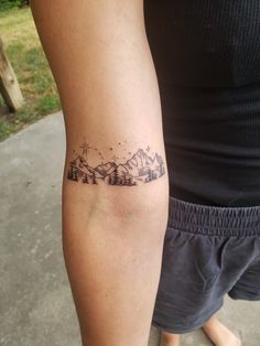 a person with a mountain tattoo on their arm