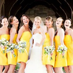 a group of women standing next to each other in yellow dresses