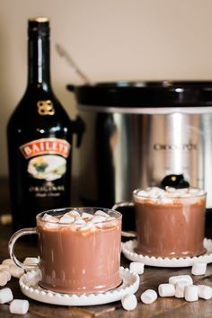 two cups of hot chocolate with marshmallows on the side and an instant pot in the background