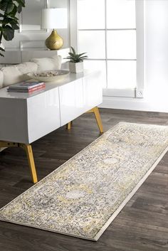 an area rug is shown in front of a white cabinet and window with a potted plant