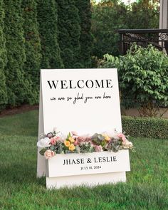 a welcome sign in the grass with flowers