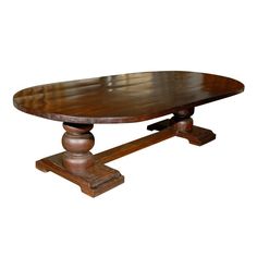 an oval wooden table with two pedestals on each side and one leg at the end