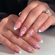 A fresh take on the classic French manicure, featuring white tips adorned with colorful floral designs. The flowers add a pop of color and a touch of whimsy to the traditional style. The smooth, oval shape and glossy finish enhance the overall playful and vibrant look, perfect for summer.@nails_by_cnd Summer Nails Inspiration, Nails French Tips, White French Tips, Summer Nails Summer, Summer Nails 2024, Nails Floral, March Nails, April Nails, May Nails