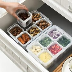 a person picking up food from an organized drawer