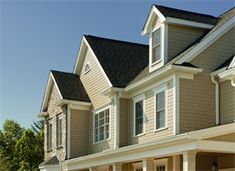 a row of houses with brown siding and white trim