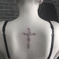 a woman with a cross tattoo on her back