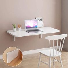 a laptop computer sitting on top of a white desk next to a chair and potted plant