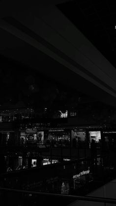 black and white photograph of city lights in the dark night time, taken from an escalator