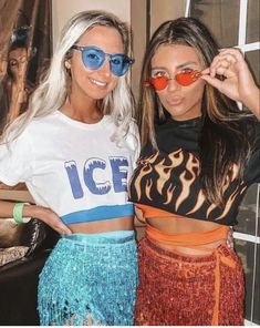 two beautiful women standing next to each other in front of a window wearing matching sunglasses