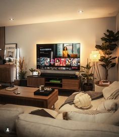 a living room filled with furniture and a flat screen tv on top of a wooden table