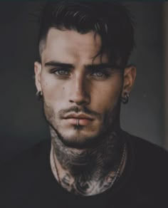 a man with tattoos and piercings on his face is looking at the camera while wearing black