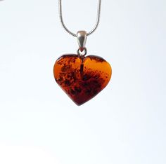 Baltic amber gemstone heart pendant. Small brown/ cognac amber heart pendant. Heart shaped jewelry. This natural Baltic amber heart shaped pendant been made of large amber stone that has been hand carved and polished into a beautiful heart. Pendant is  suitable for everyday wearing and special occasions. It is a talisman believed to bring  health, happiness and success in love. My items come inside a small box, ready for gift giving and perfect for storage. Length approximately  18mm / 0.7 inche Brown Heart Charm Jewelry Gift, Heart-shaped Brown Necklace For Gift, Brown Heart-shaped Necklace For Gift, Amber Heart Pendant Jewelry Gift, Heart Pendant Amber Jewelry For Gift, Brown Heart Charm Necklace As A Gift, Brown Heart Charm Necklace As Gift, Heart-shaped Orange Jewelry For Gift, Brown Necklace With Heart Charm For Gift