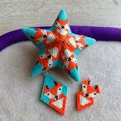 an orange and blue beaded star with two earrings