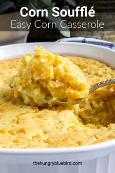 a spoonful of mashed potatoes in a white casserole dish next to a potted plant