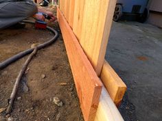 a man is working on the side of a wooden building with measurements for wood framing