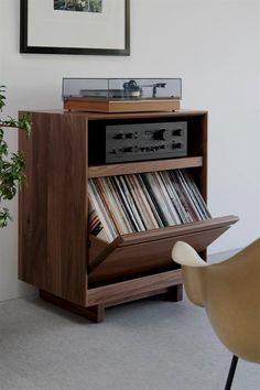 an old record player is sitting on top of a wooden cabinet with records in it