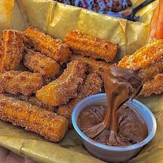 chocolate sauce being drizzled on some food in a basket with carrots