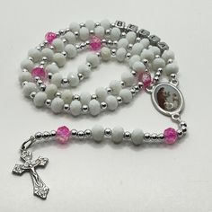 This beautiful and delicate personalized First Communion rosary for a girl or boy is a beautiful and meaningful gift for that special day of First Communion. This handmade religious jewelry is made with a beautiful Italian medal and the name of the boy or girl who will receive it and will be a permanent memory of that special day. It is a lasting reminder of God's love and blessing, as well as a special gift from godmother, aunt or grandmother to celebrate this important milestone and a reminder of faith that can be used daily. The perfect gift to express your love and faith! PRODUCT DETAILS: The Delicate Rosary is made with white glass, and with details in blue or pink depending on the case and silver details, as well as the name of the boy or girl who will receive it, made entirely by ha White Spiritual Jewelry For Confirmation, Spiritual White Jewelry For Confirmation, White Rosary Bracelet For First Communion, Adjustable Miraculous Medal For Gift, White Spiritual Rosary With Miraculous Medal, Spiritual White Rosary With Miraculous Medal, Handmade White Jewelry For Confirmation, White Spiritual Necklace For Mother's Day, White Spiritual Cross Jewelry And Charms