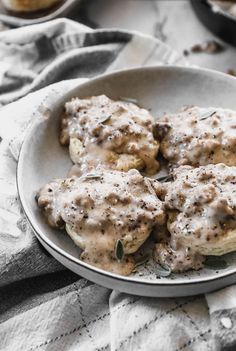 a white plate topped with meat covered in gravy