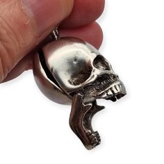 The rare sterling silver pendant is a very well-made piece of jewelry with a detailed skull that not only stands out for its realism, but also features an articulated jaw. This box pendant is quite unique as it opens to reveal a hidden compartment, ideal for storing small secrets or personal charms. *Dimensions It measures 3 cm long and 2 cm wide, approximately. *Weight: Weighs 14.48 grams. **Composition Main material: Silver Hallmark: 925 hallmark visible on the jaw. Acid test: performed. Other materials: not continued. **Additional details: not new and has signs of use, please look at the photos carefully. Pay attention to the details! Product condition Each item we offer is a unique piece with its own history and distinctive character. Although they may show slight signs of use, we take Gothic Skull Ring With Polished Finish Gift, Gothic Skull Ring With Polished Finish, Collectible Silver Skull Jewelry, Gift Skull Ring With Polished Finish, Skull Ring With Polished Finish As Gift, Collectible Skull Jewelry In Lost Wax Casting, Antique Engraved Skull Ring As Gift, Antique Silver Skull Ring Gift, Antique Engraved Skull Ring For Gift