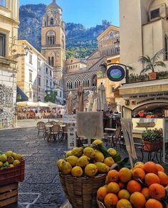 there are many fruits and vegetables on display in this street side market area, including oranges