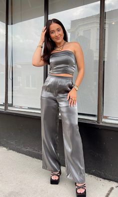 FINAL SALE It's giving GLAM. This gunmetal metallic strapless top with a fold over neckline would be PERFECT for a night out in the city! Pair it with our "Giving Glam Pant" to complete the set. Model is 5'2" with a 34A bust, 25" waist, 34" hips, and wearing a size small. Model usually 2/4. This item runs true to size! Satin Clothing, Glam Tops, Lingerie Drawer, Satin Pants, Satin Blouses, Silver Tops, Feminine Beauty, Fold Over, Satin Dresses