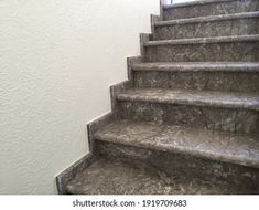 a set of stone stairs leading up to a window in a white walled room with light coming through the window