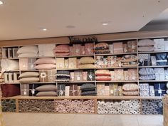 the shelves are filled with many different types of pillows and blankets, all stacked together