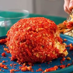 a person is eating food on a blue plate with crackers and sauce in the background