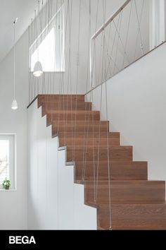 the stairs are made of wood and have metal strings hanging from each handrails