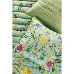 the comforter is made up of many different colors and patterns, including flowers on it